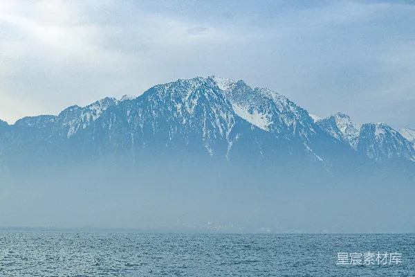 白天山脚下有雪覆盖的山脉靠近水域