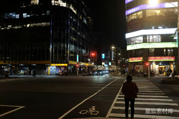 高清摄影 一个人站在人行横道上，夜色中。