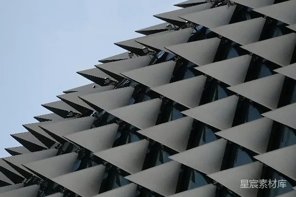 高清摄影 现代建筑外墙上的重复三角形图案与蓝天相对。