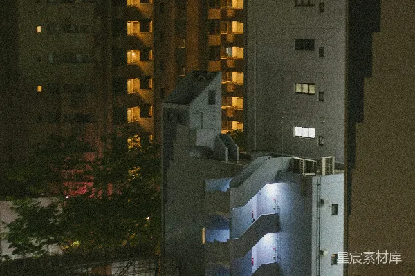 高清摄影 夜晚，公寓楼的窗户发出明亮的光芒。
