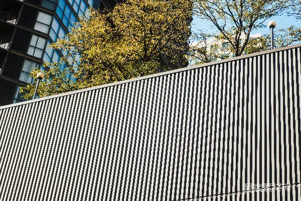 高清摄影 现代建筑外立面，带有垂直百叶窗和树木