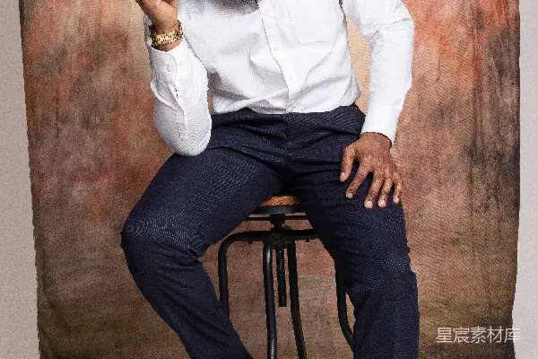 一个男人坐在凳子上戴着一顶帽子