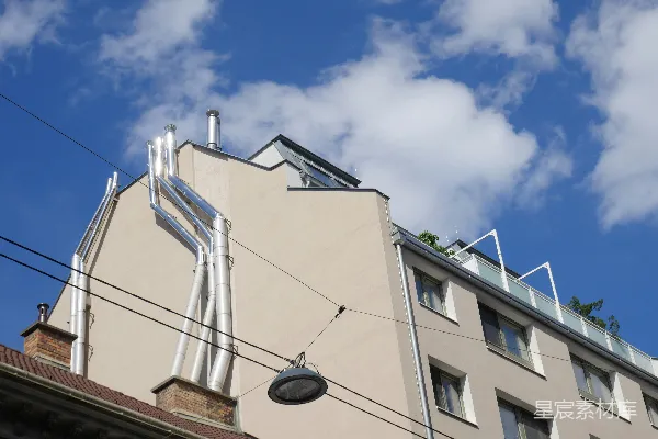 高清摄影 建筑物外墙上的闪亮金属管道在蓝天背景下。
