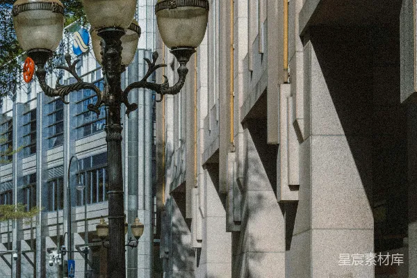 高清摄影 一个女子沿着阳光斑驳的城市人行道走着。