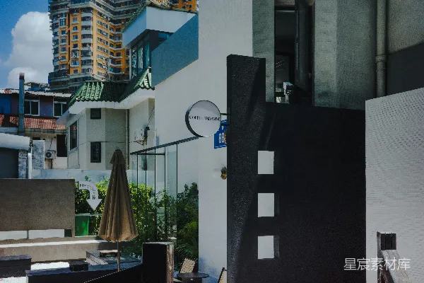 高清摄影 现代建筑外立面，有黑色大门和雨伞。