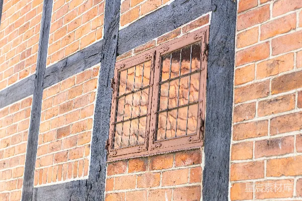 一座砖砌建筑的窗户有网格装饰。