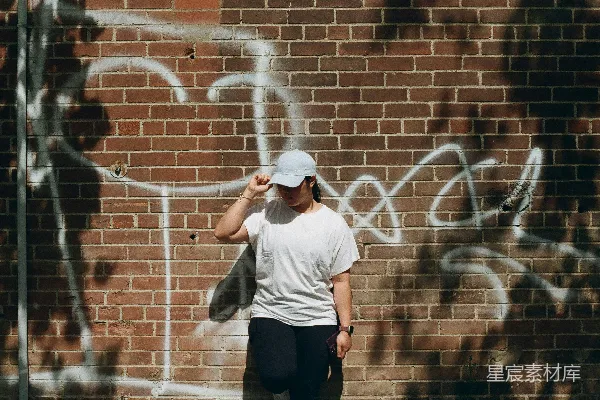 一个男人站在一面砖墙面前