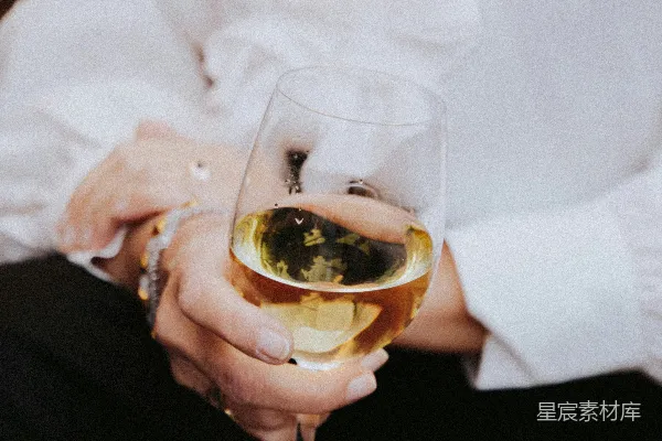 手持透明酒杯的人