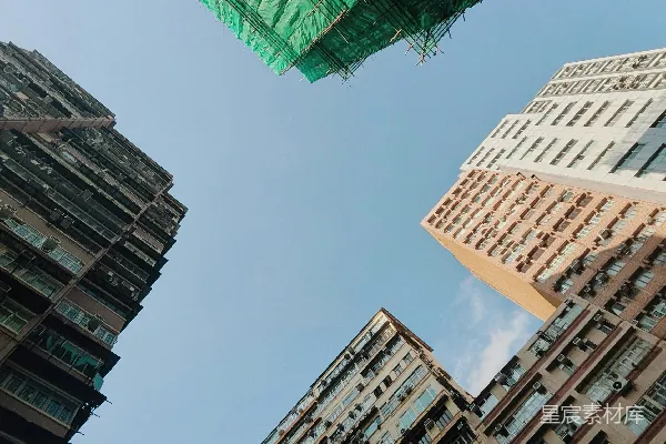 高清摄影 城市中的建筑物直指天际，一座建筑物下覆盖着绿色的施工网。