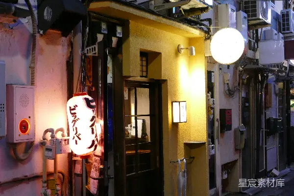 夜晚一条狭窄的城市街道，灯火通明。