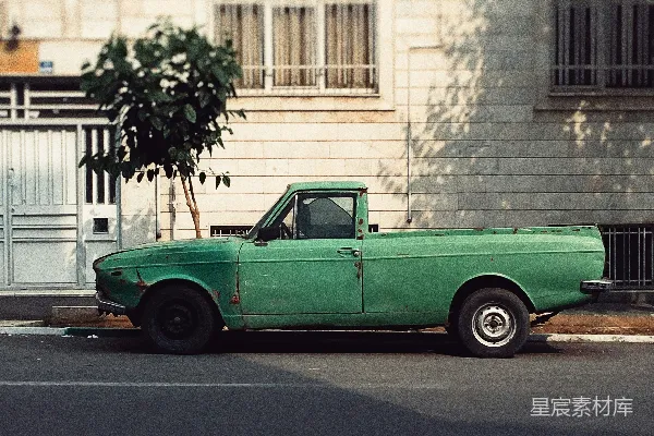 高清摄影 绿色的单排座皮卡车停在建筑物旁边。