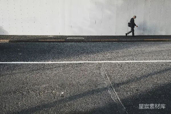高清摄影 一个人在白墙附近行走。