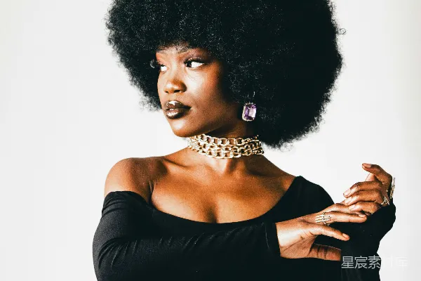 一个留着 Afro的妇女正在拍照。