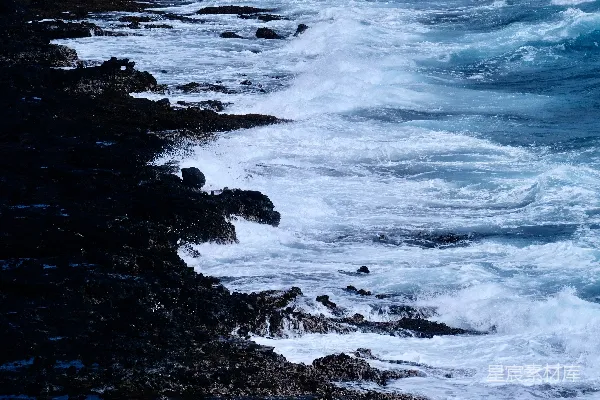 阳光明媚的一天里，波浪撞击着岩石海岸。