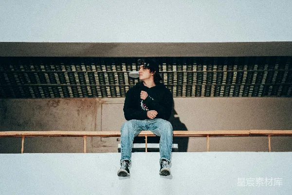 一个男人坐在木制长凳的顶端。