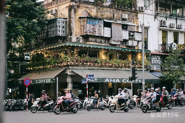 高清摄影 白天，人们在建筑物附近的道路上骑摩托车。