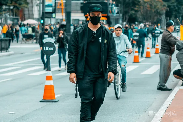 高清摄影 穿黑色夹克和黑色帽子的人骑着黑色滑板车在灰色混凝土路上。