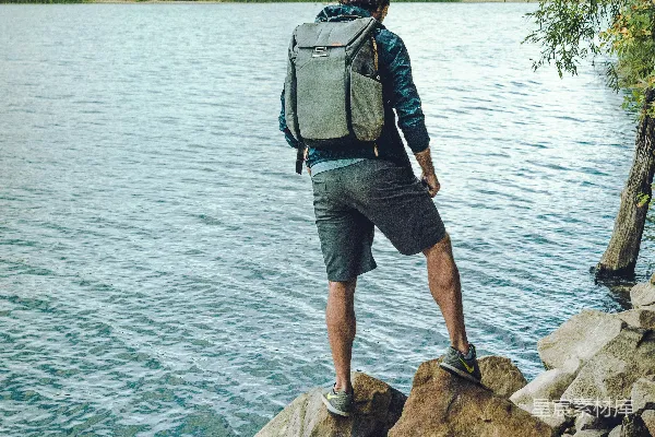 白天一名男子站在岩石结构前的平静水面边