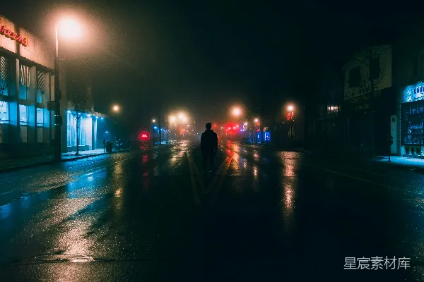 高清摄影 一个穿着黑色夹克的男人在夜间人行道上行走。