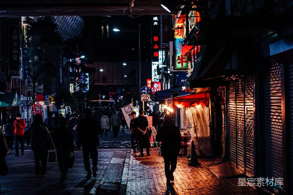高清摄影 一群人在夜晚沿着街道行走。