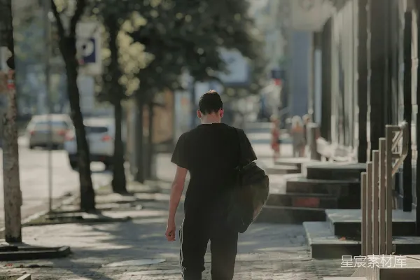 高清摄影 穿黑色连帽衫的男人在白天的人行道上行走。