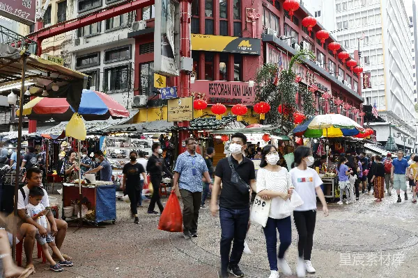 高清摄影 一群人沿着街道行走，街道两旁是高楼大厦。