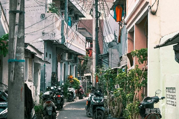 高清摄影 一条狭窄的城市街道，两旁停着摩托车。