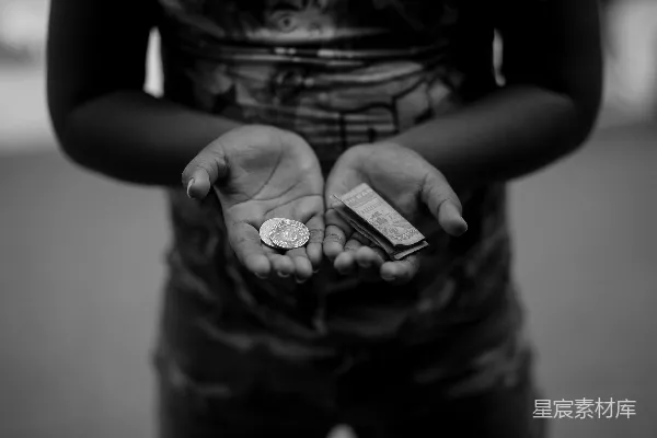 高清摄影 一张黑白照片，一个人手里拿着一枚硬币。