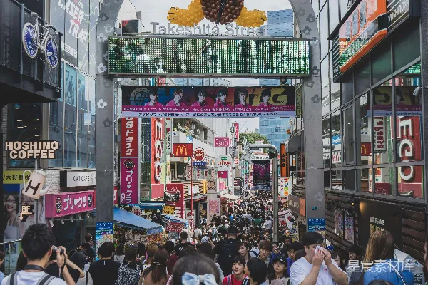 高清摄影 一群人走在街道上，旁边有一个大标志牌。
