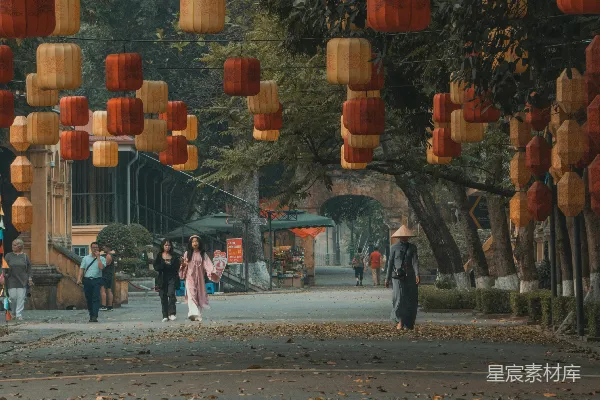 高清摄影 一队人在橙色灯笼下沿着街道行走。