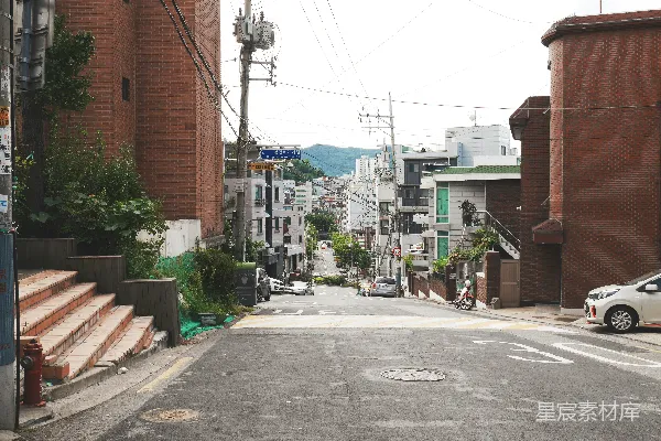 高清摄影 白天间，灰色水泥路夹在棕色水泥建筑之间。
