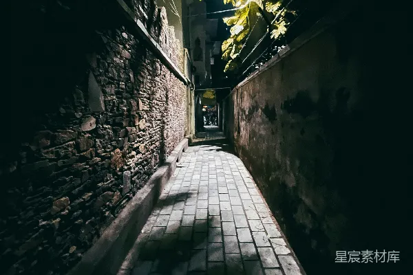 高清摄影 一条昏暗的小巷，砖砌的人行道通向一栋建筑。