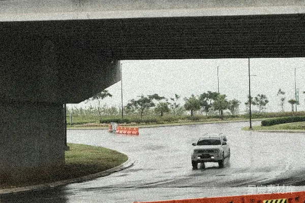 高清摄影 一辆汽车在桥下的湿路上行驶。