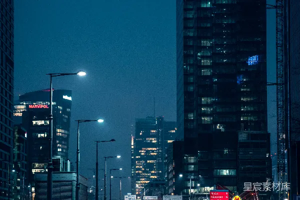 高清摄影 夜晚在高楼大厦附近道路上行驶的汽车