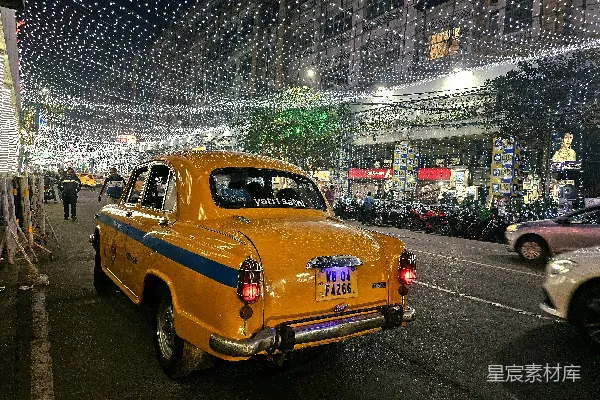 高清摄影 一辆黄色出租车沿着街道行驶，旁边停着几辆汽车。