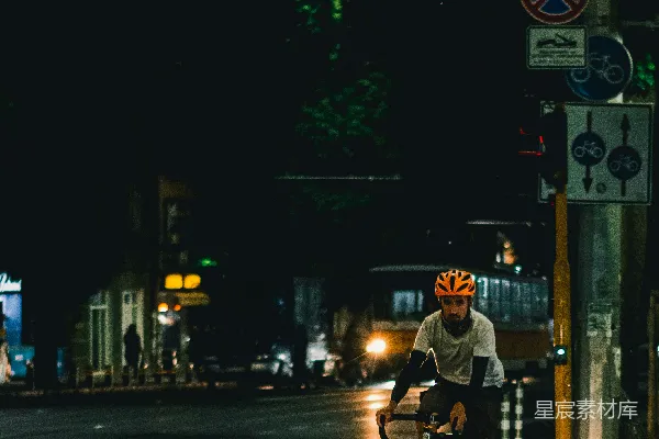 高清摄影 穿着黑色夹克的男人在夜间街道上骑自行车