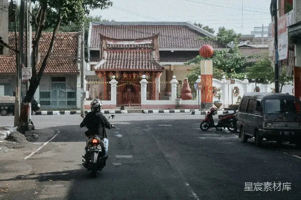 高清摄影 一个男人骑着摩托车沿着街道行驶。