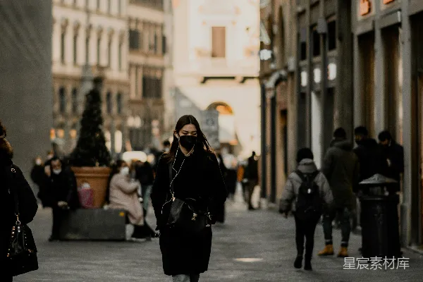 高清摄影 一位女士在高楼大厦旁的街道上行走。