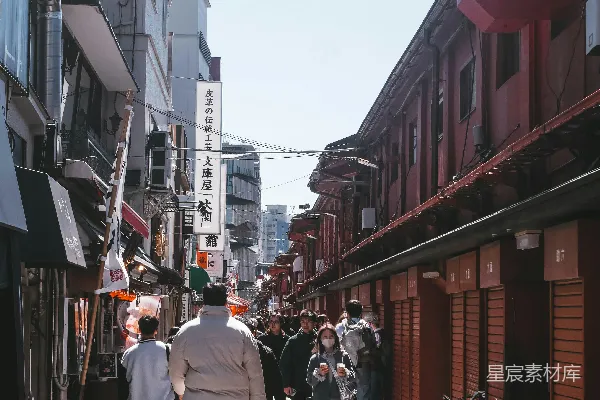 高清摄影 人们走在一条狭窄的街道上，街道两旁是商店。