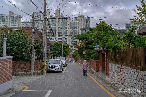 高清摄影 一个女人沿着一排高楼大厦行走。