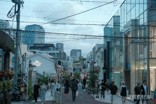 高清摄影 一群人沿着街道行走，旁边是高楼大厦。