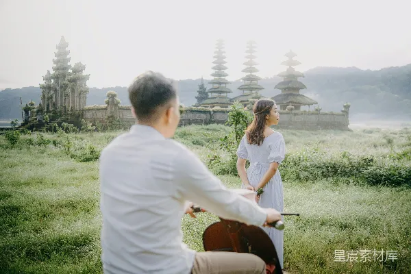 一个男人和一个女人骑在一辆自行车后面。