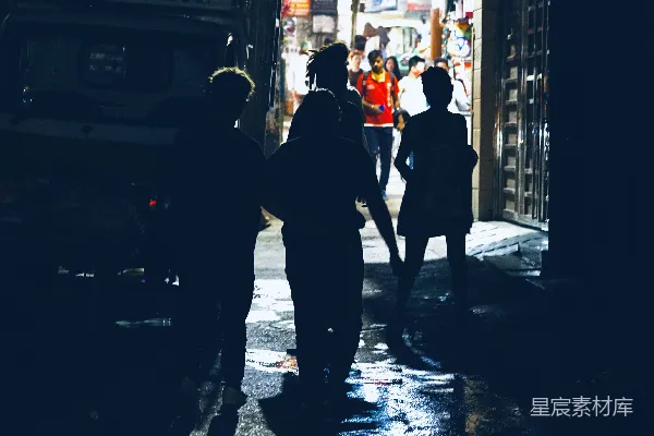 高清摄影 一群人在夜晚沿着街道行走。