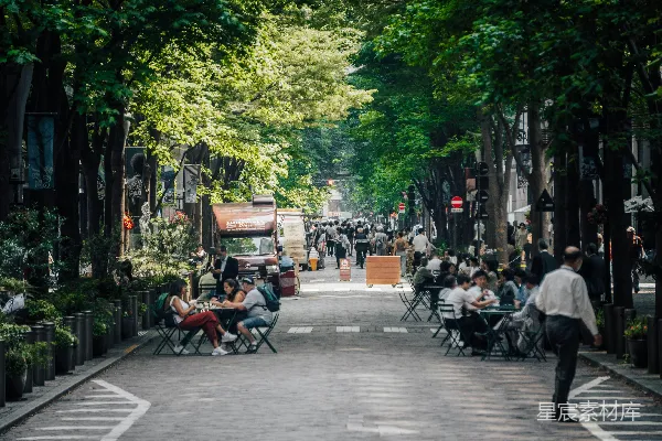 一群人在街道上坐着桌子用餐