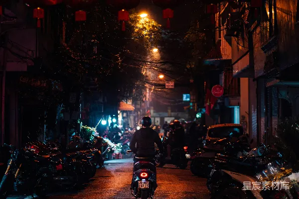 高清摄影 一个男人在夜晚沿着街道骑摩托车。