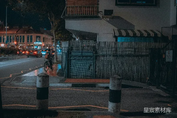 高清摄影 一个骑自行车的人在夜晚的城市街道上行驶。