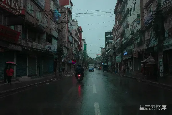 高清摄影 一辆车在高楼旁边的路上行驶。