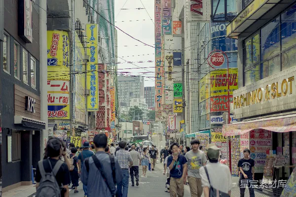 高清摄影 一群人沿着街边高大的建筑物旁行走。
