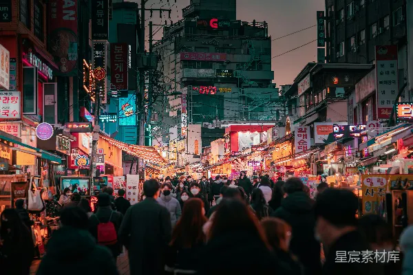 高清摄影 一群人沿着街道行走，旁边是高楼大厦。