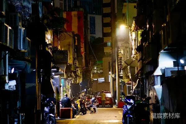 高清摄影 夜晚的一条城市街道，街道一侧停着摩托车。